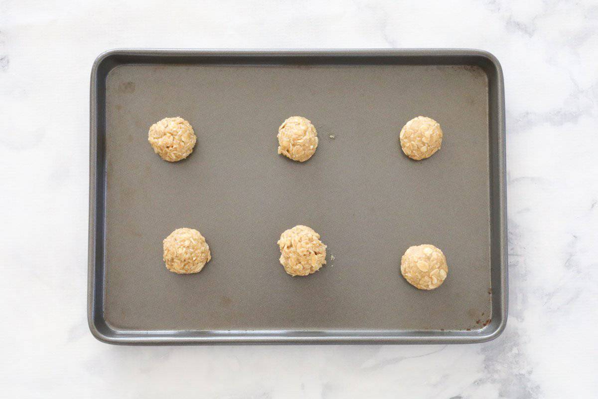 Rolled oat biscuits on a baking tray.