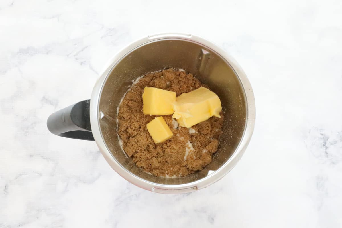 A Thermomix mixing bowl with cubes of butter and brown sugar