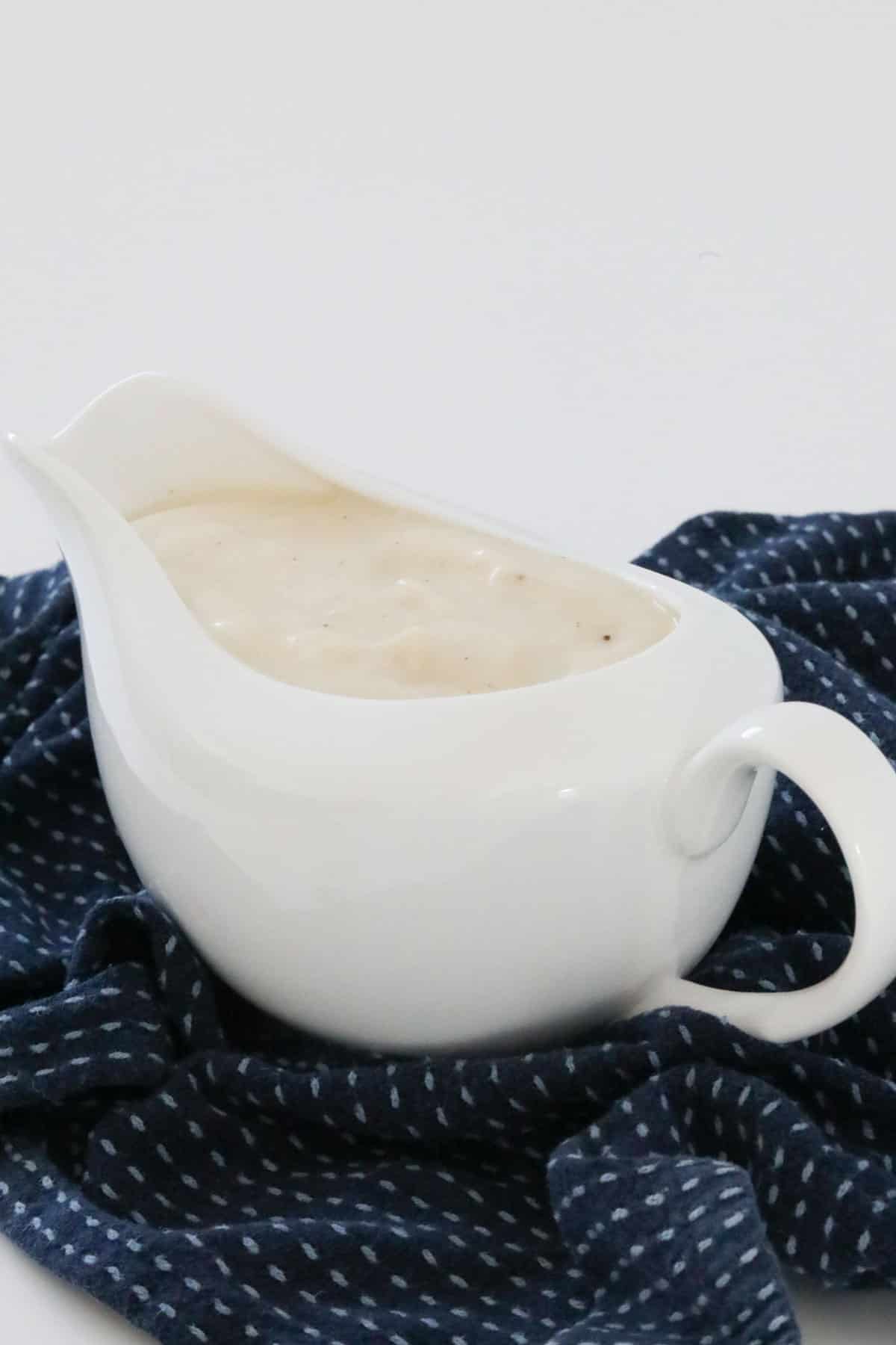 A white serving jug filled with white sauce.
