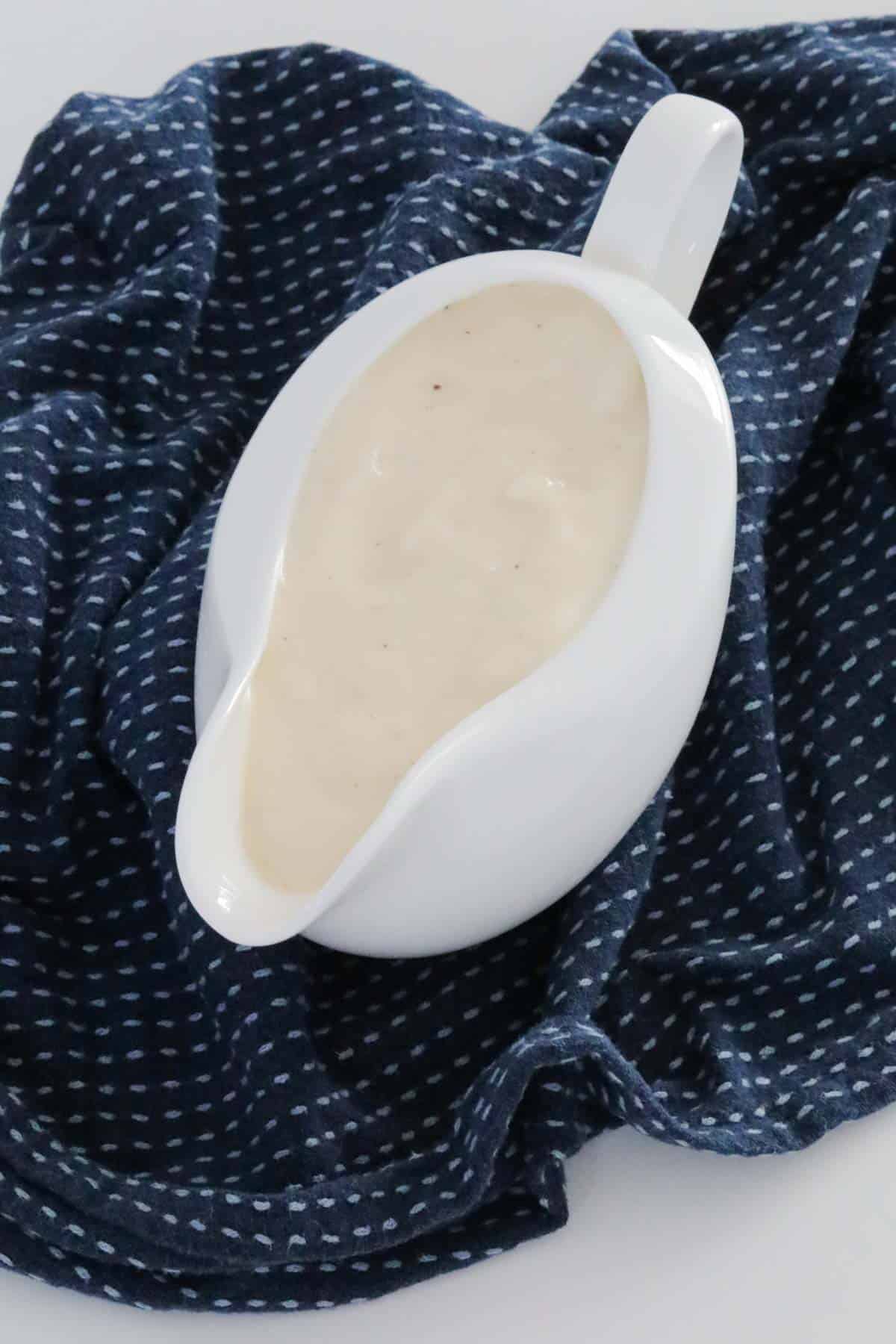 A creamy bechamel sauce in a white jug.