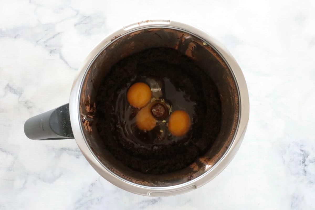 A Thermomix bowl with eggs and chocolate mixture.