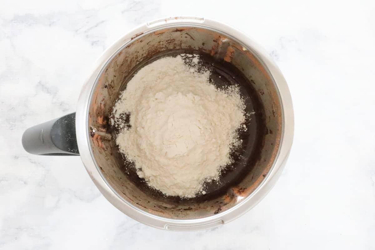Flour on top of chocolate mixture in a stainless jug.