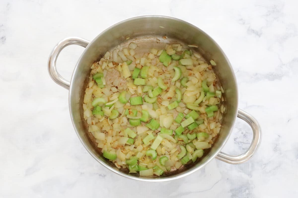 Celery and onion sauteing in a pot