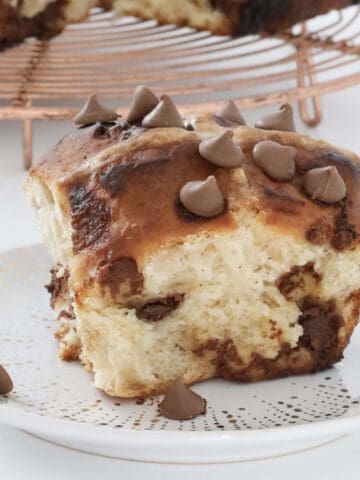 Chocolate chips on top of a hot cross bun.