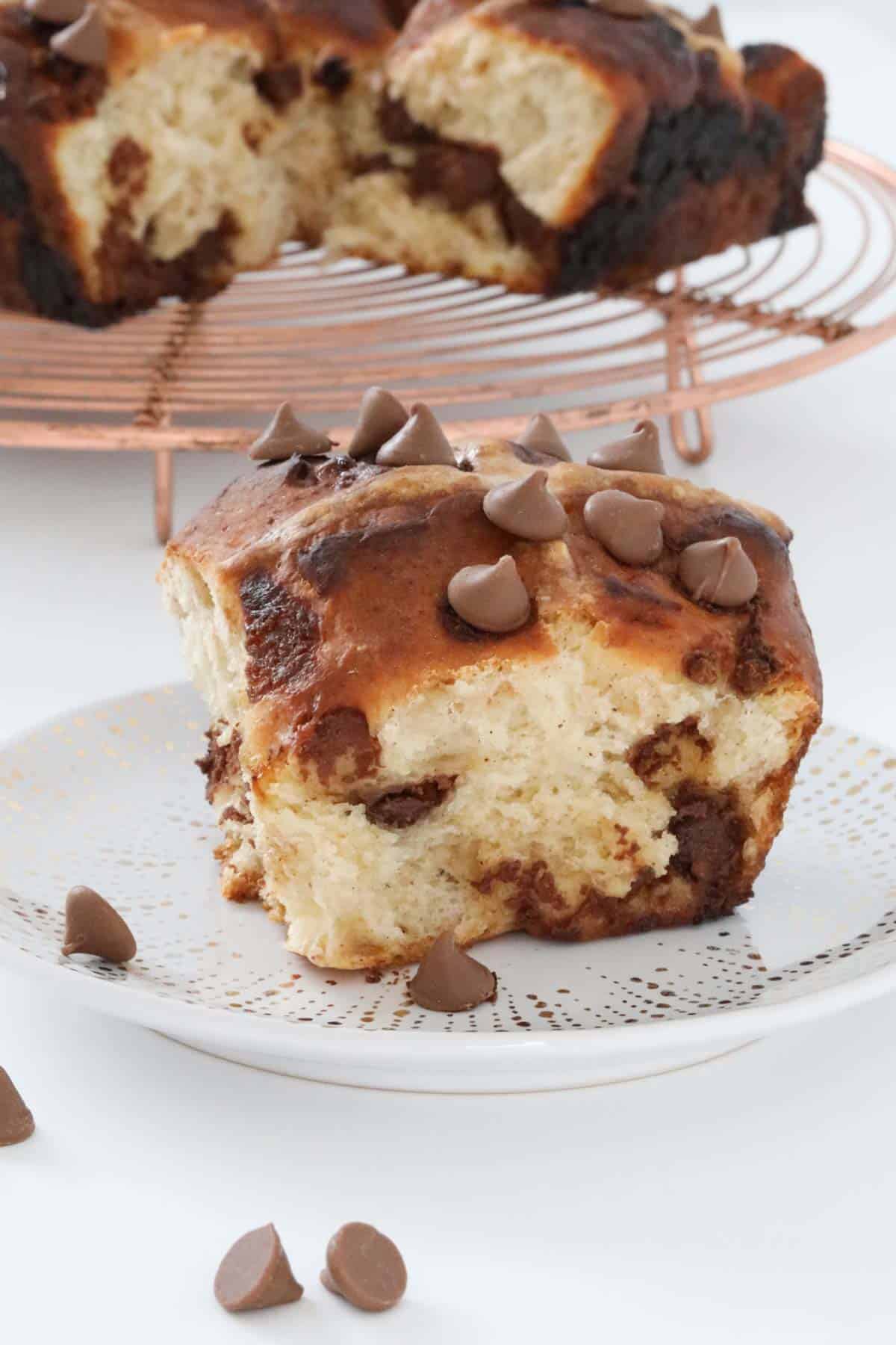 Chocolate chips on top of a hot cross bun.