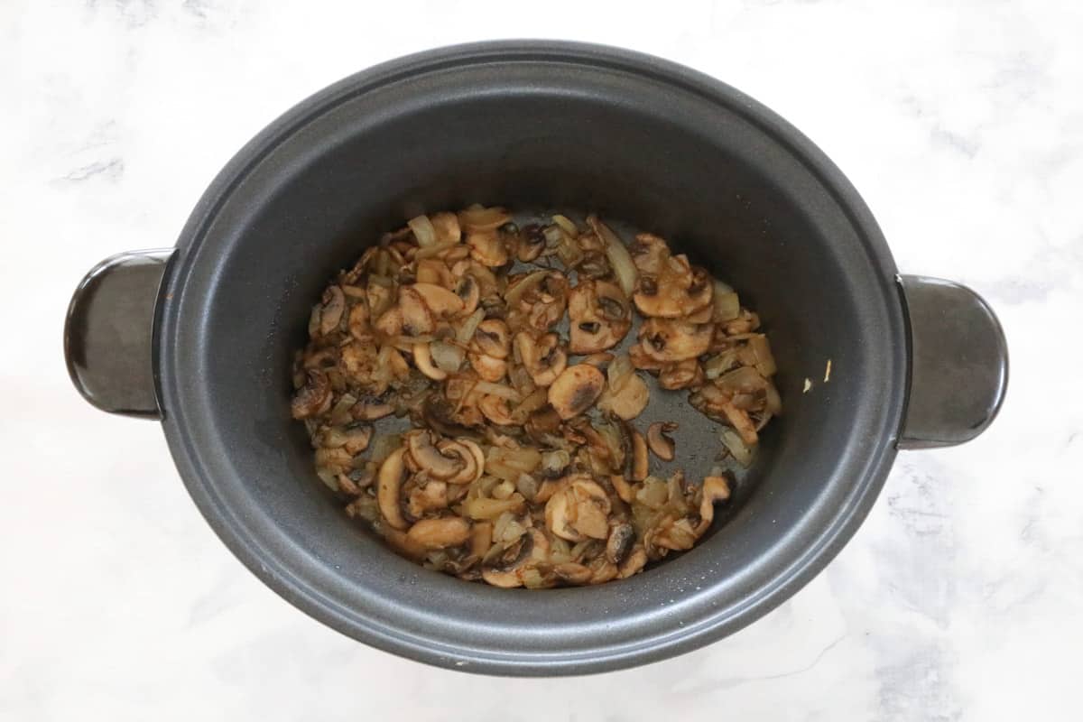 Onion and mushroom in a slow cooker pot