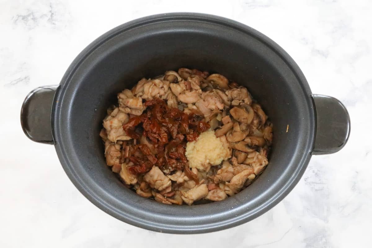 Chicken and sun dried tomatoes in a slow cooker pot