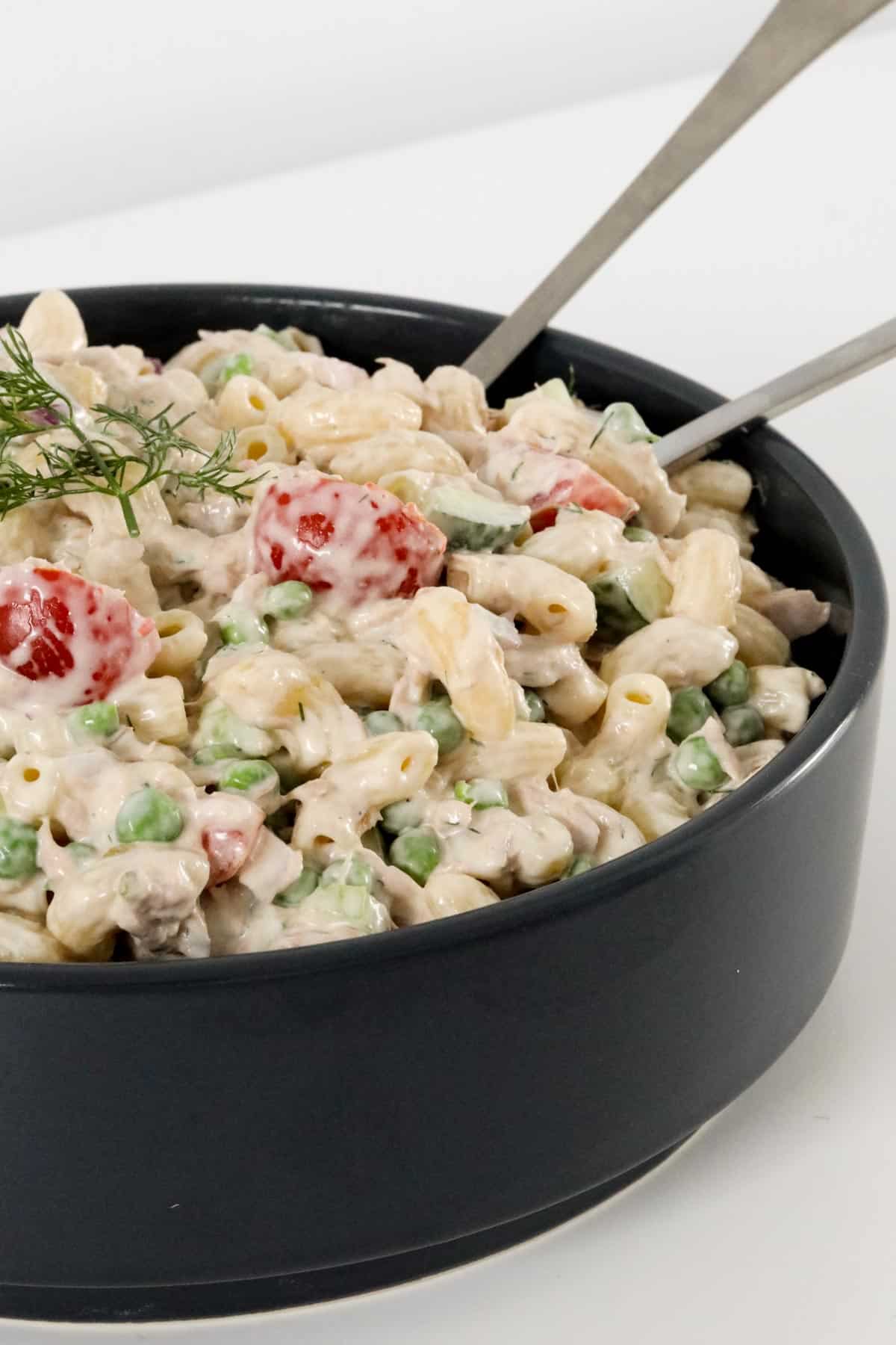 A black bowl filled with tuna pasta salad