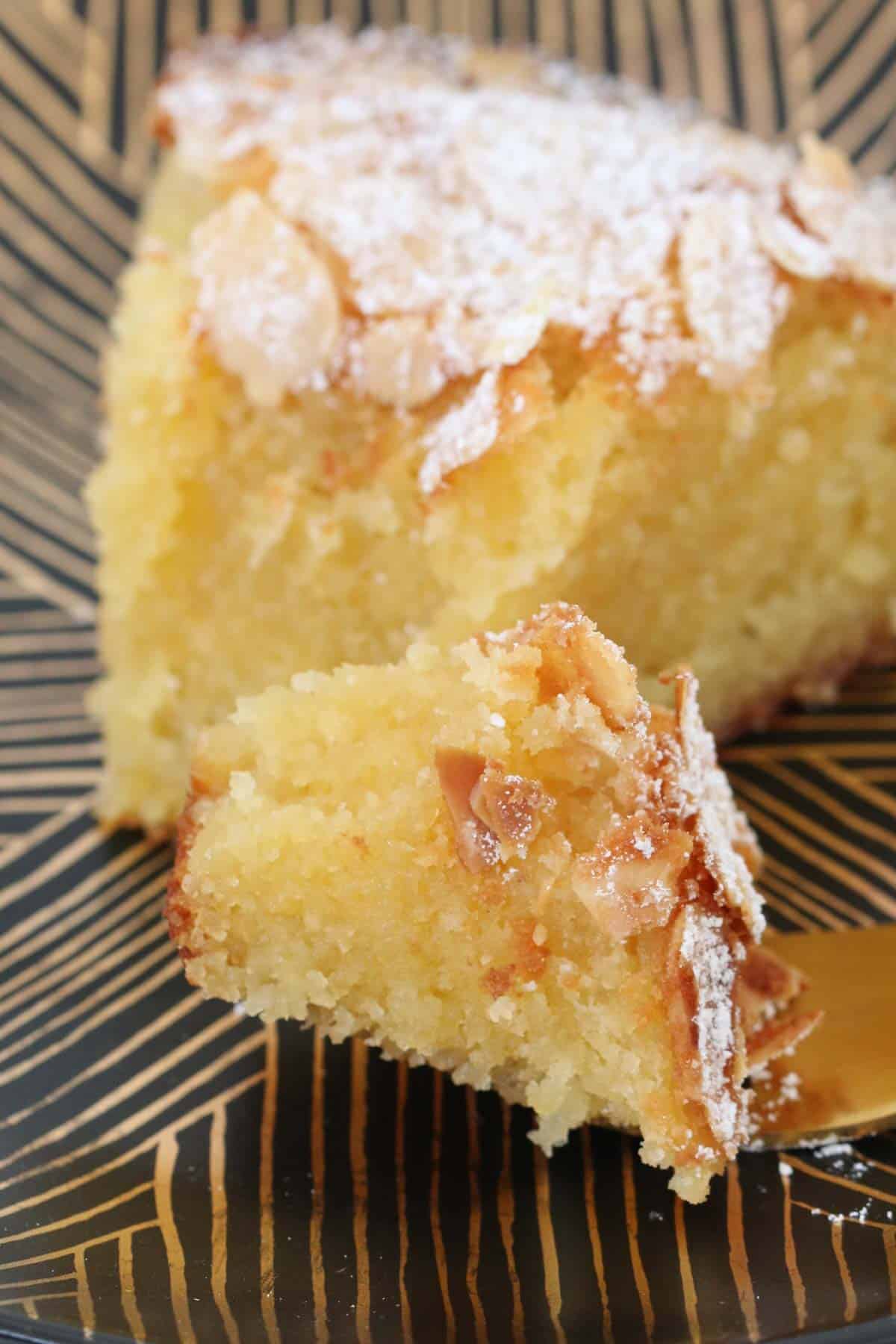 Moist almond cake close up, with a fork breaking off a mouthful.