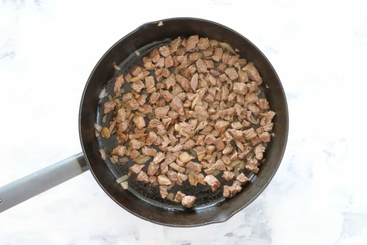 Beef pieces cooking in a frying pan