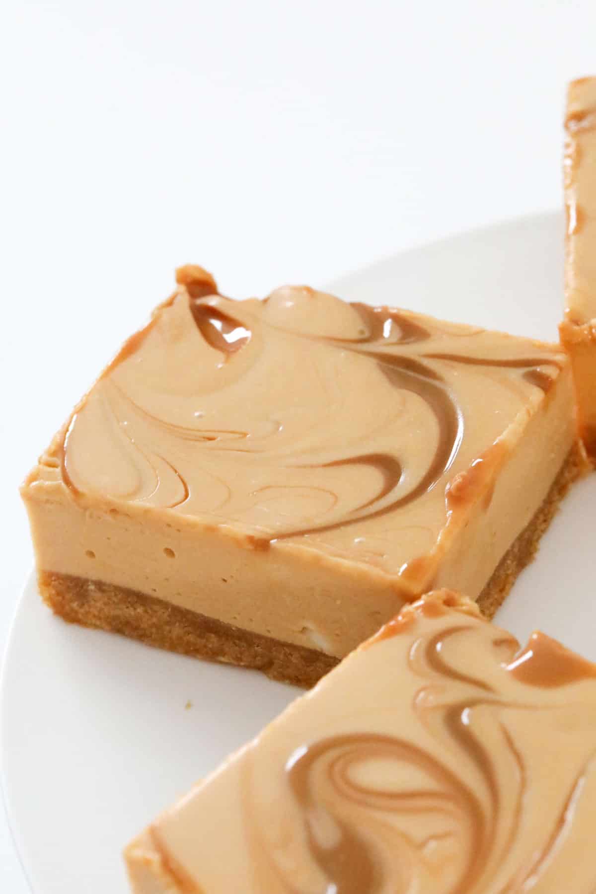 Squares of a caramel slice swirled with caramel sauce.