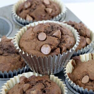 A stack of double chocolate and banana muffins in silver cases.