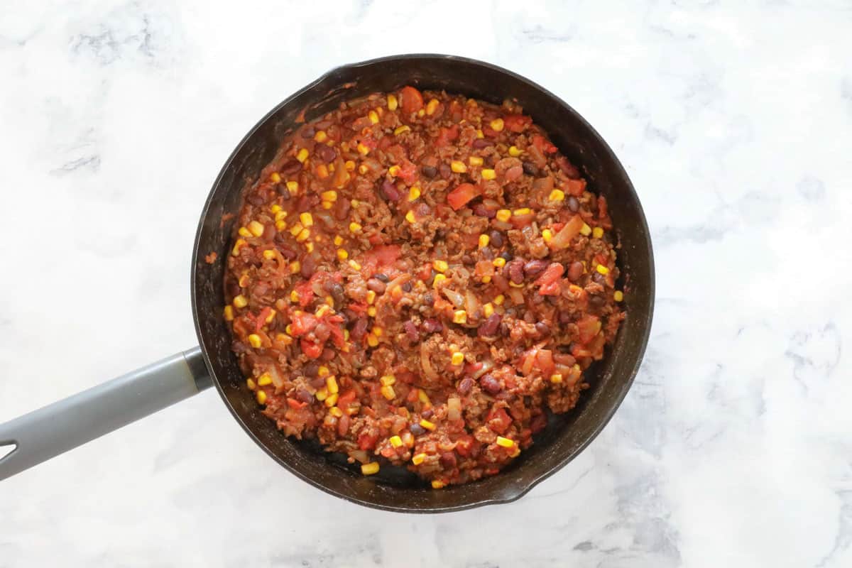 Mexican meat filling, with tomatoes and corn, in a frying pan