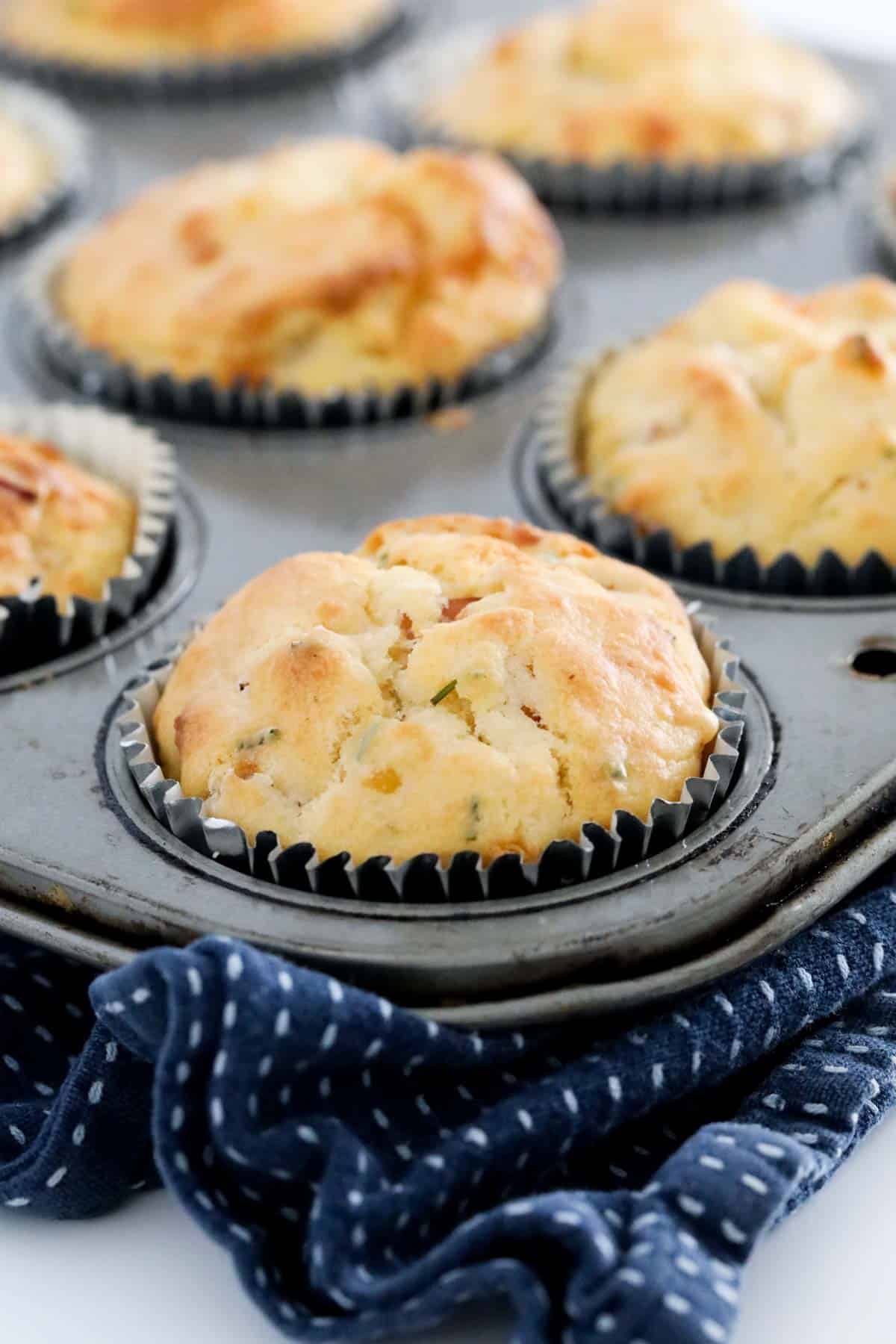 A close up of savoury muffins in paper cases in a baking tray