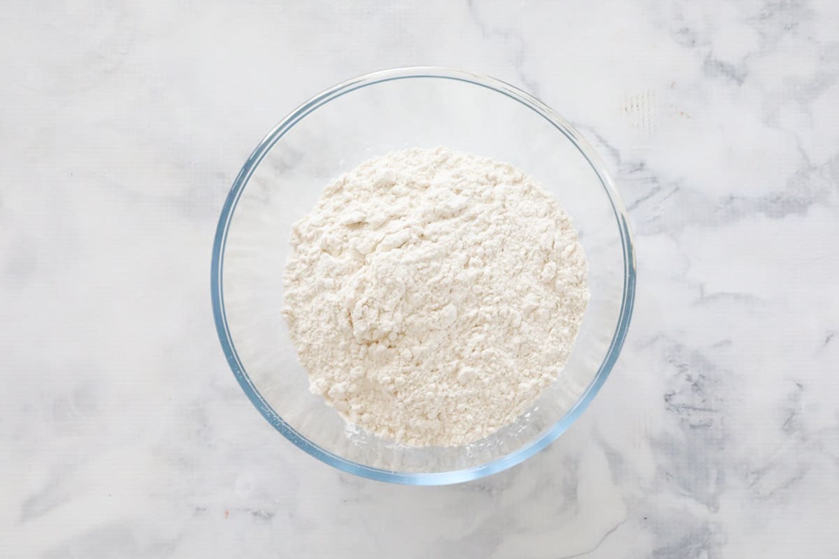 Flour, raising agents and spices combined in a glass bowl on a counter