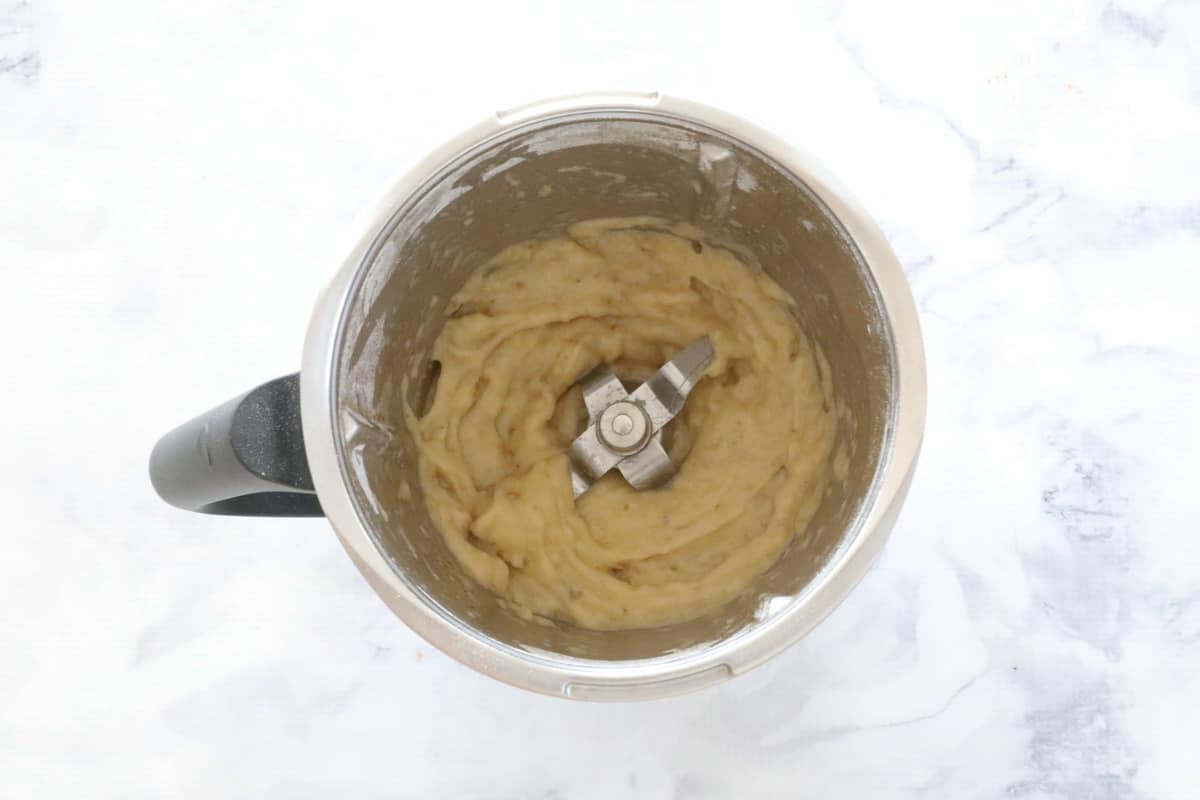 Mashed bananas in a Thermomix bowl on a marble counter