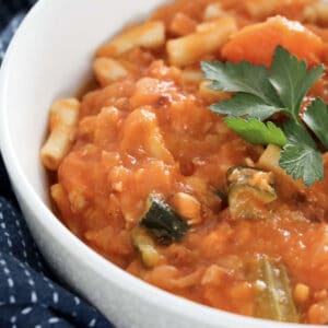 A vegetable, tomato and pasta soup in a bowl.