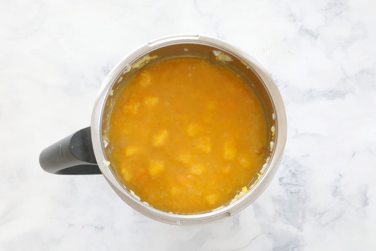 Chunks of pumpkin in a liquid stock filling a thermal cooker jug