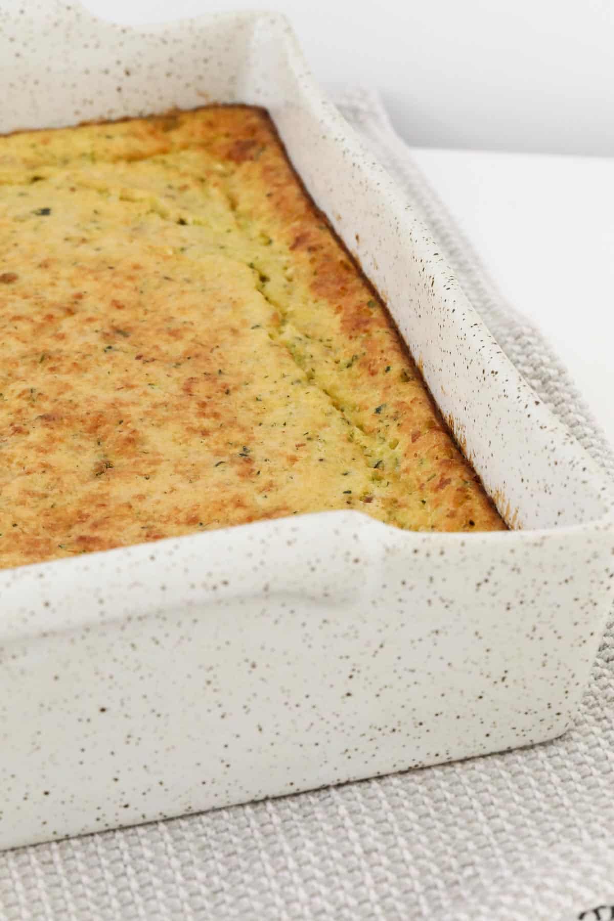 A golden baked savoury slice in a baking tin.