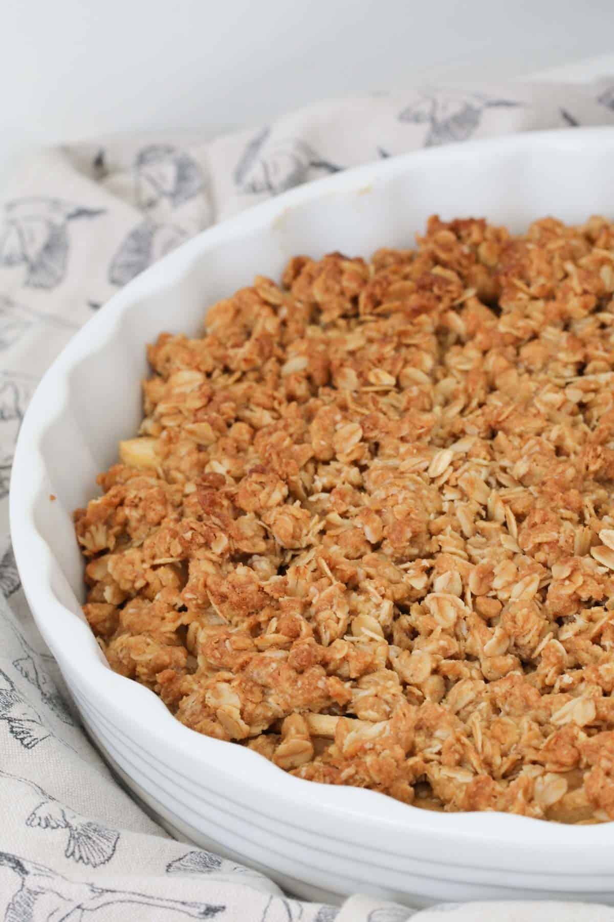 A round baking dish filled with a crunchy golden oat topping.