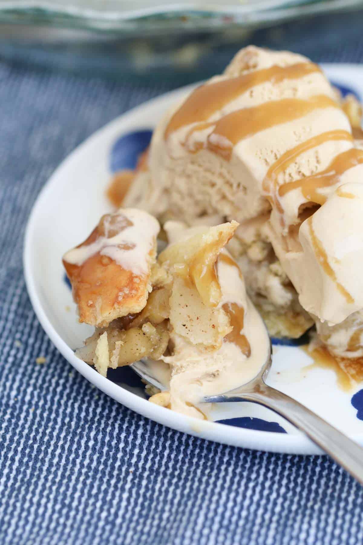 A spoonful of dessert with caramel sauce and ice cream.