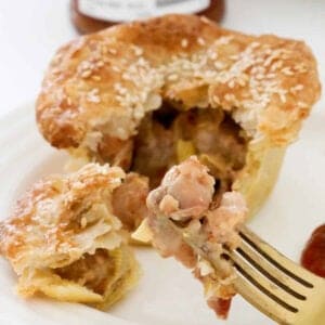 A chicken and leek pie cut open on a plate.