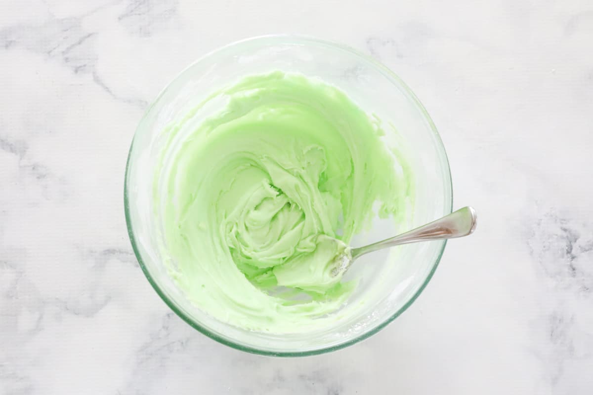 Green icing mix in a white bowl.