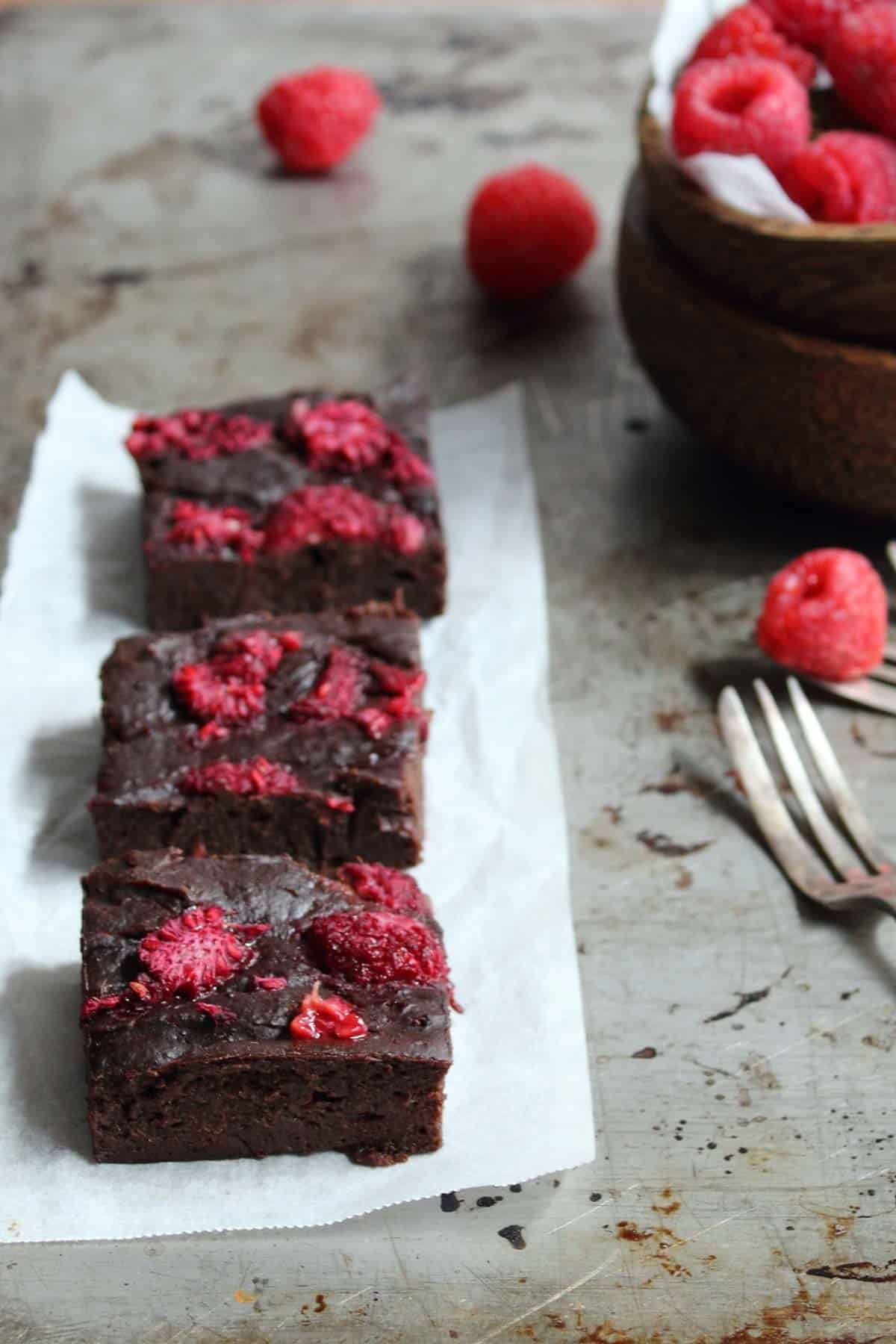 raspberry brownies arranged on a baking tray.