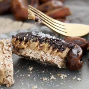 A piece of half eaten healthy caramel slice made with dates.