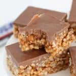 pieces of snickers slice arranged on a white stand, one with a bite missing.