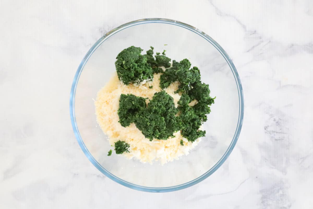 Spinach, feta and parmesan in a mixing bowl.