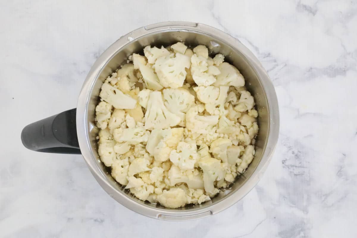 An overhead view of a Thermomix mixing bowl filled with cauliflower florets