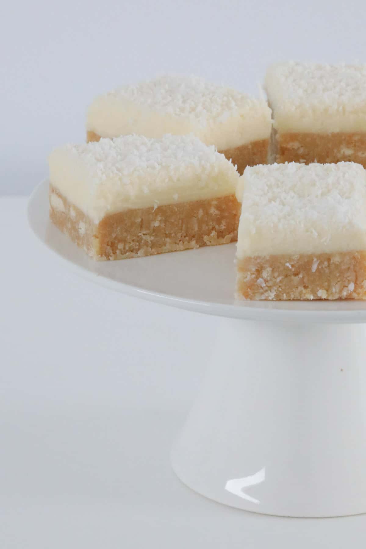 Squares of a two layer lemon slice with coconut.