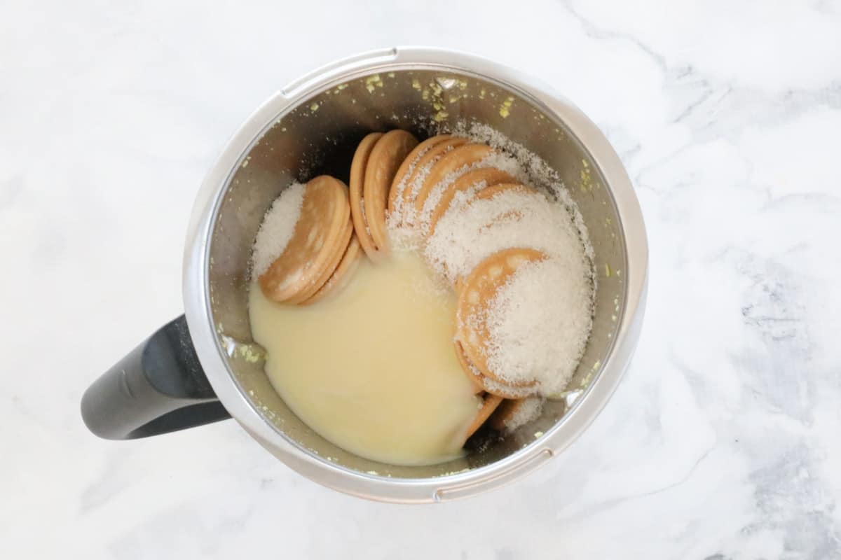 Biscuits, sweetened condensed milk and coconut in a jug.