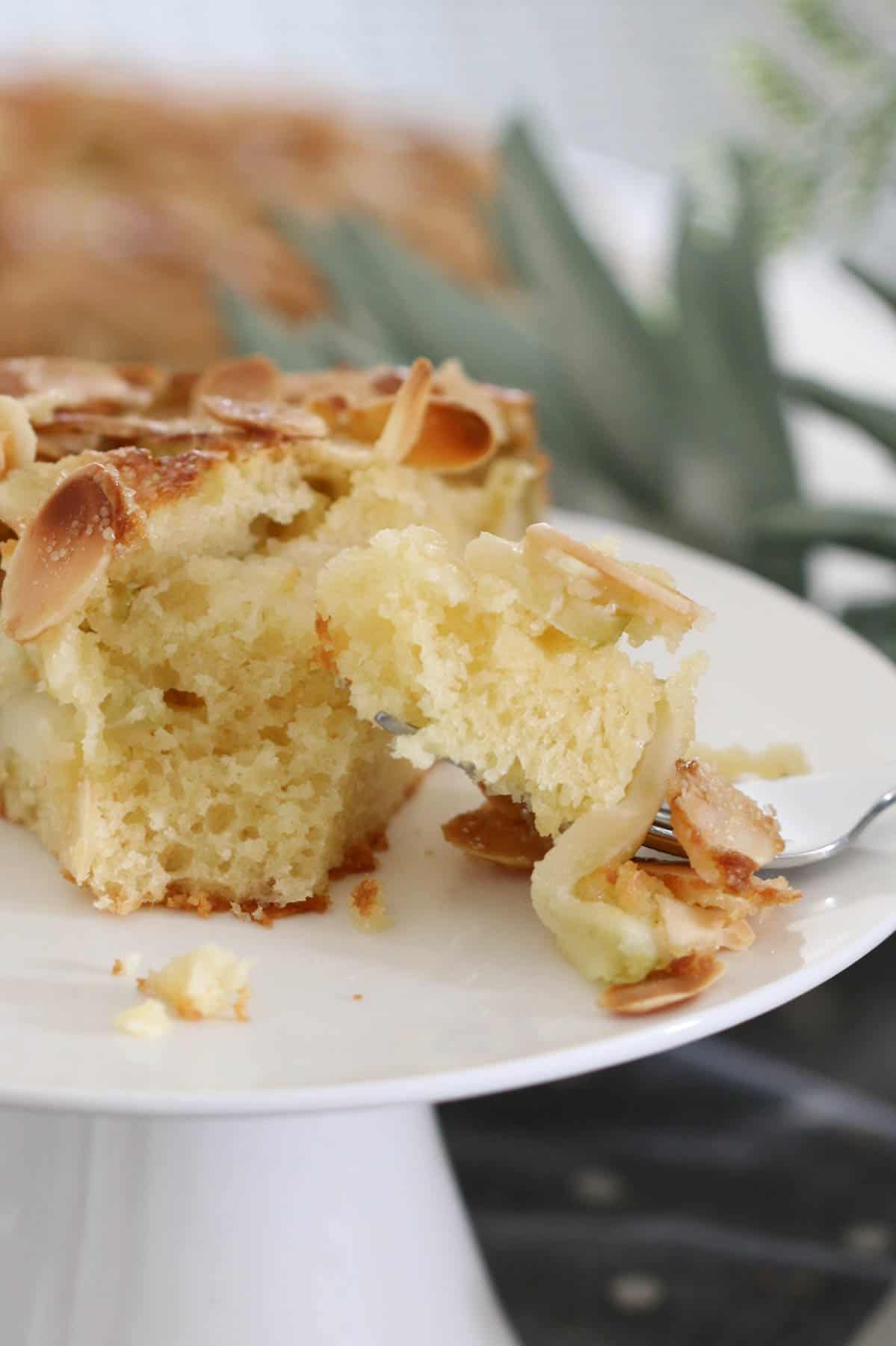 A forkful of soft butter cake with apples and almonds.