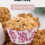 A close up of an apple crumble muffin in a pink floral muffin case.in