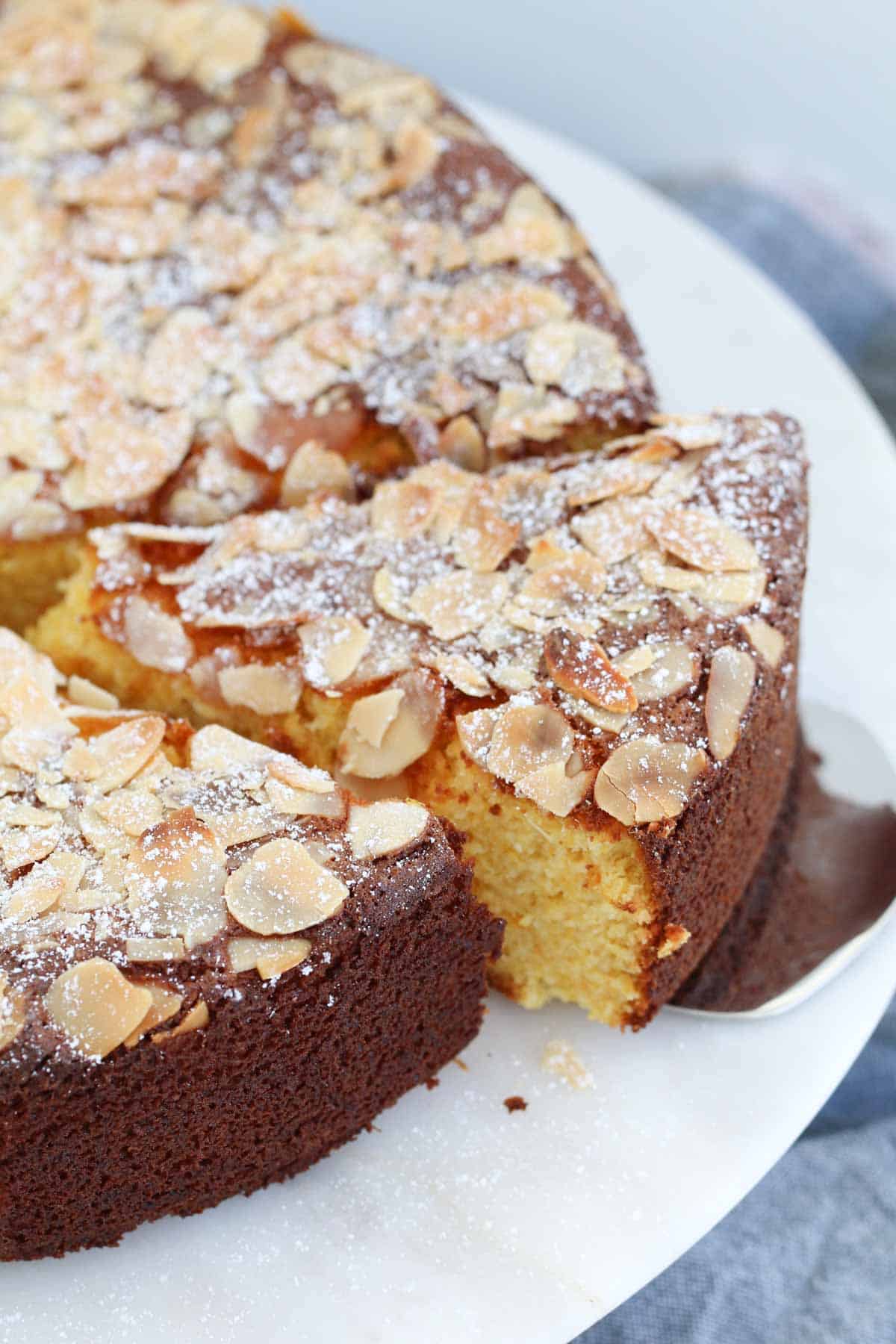 Flaked almonds on top of an orange cake.