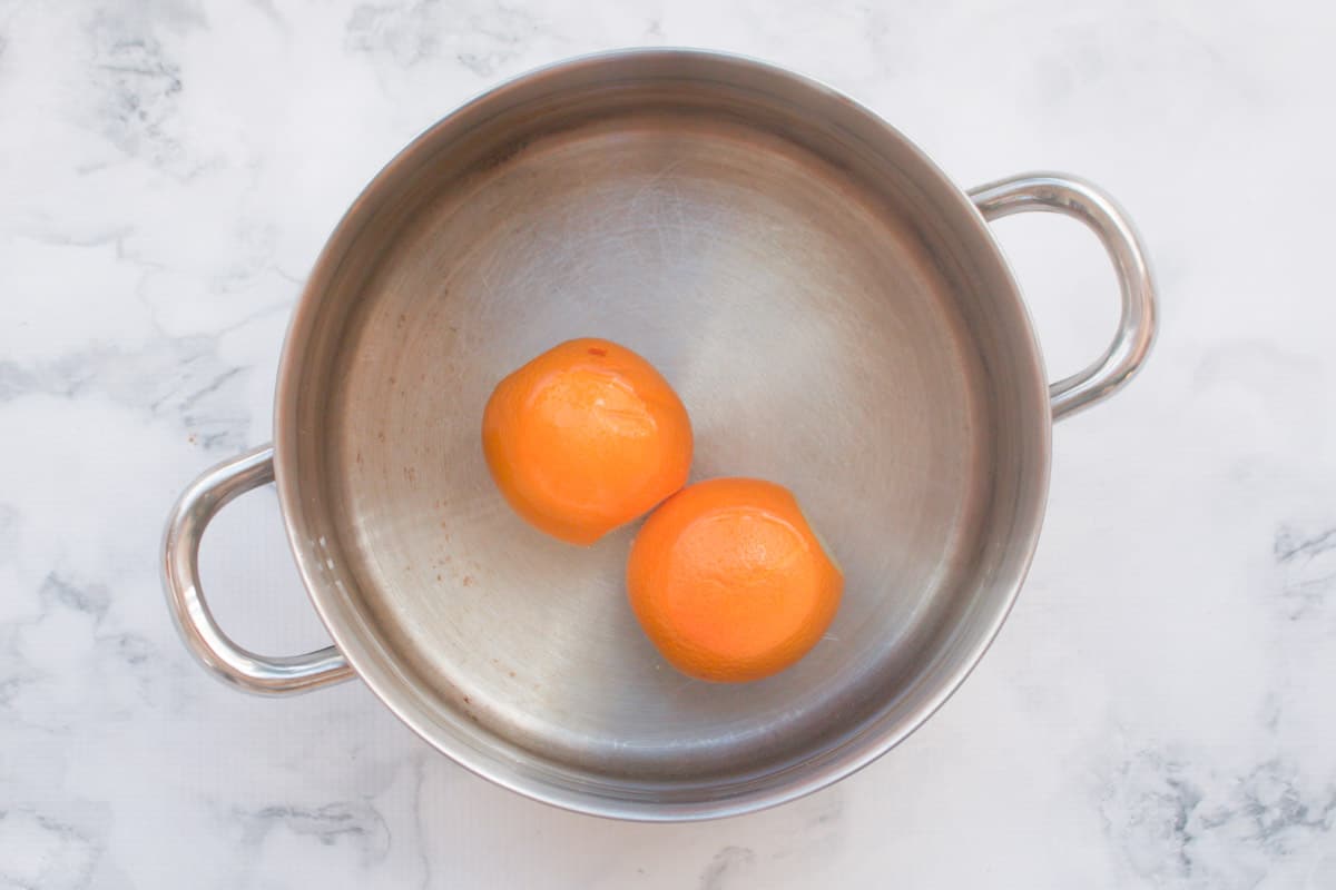 Two oranges in a saucepan.