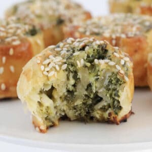 puff pastry scrolls filled with spinach and feta on a white stand.