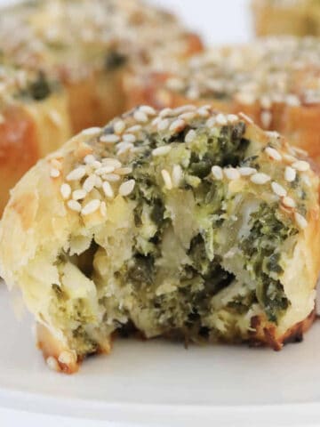 puff pastry scrolls filled with spinach and feta on a white stand.