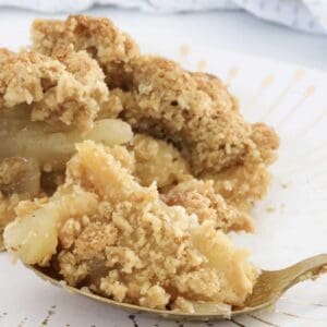 A forkful of lightly stewed apples with crunchy oat crumble on top.