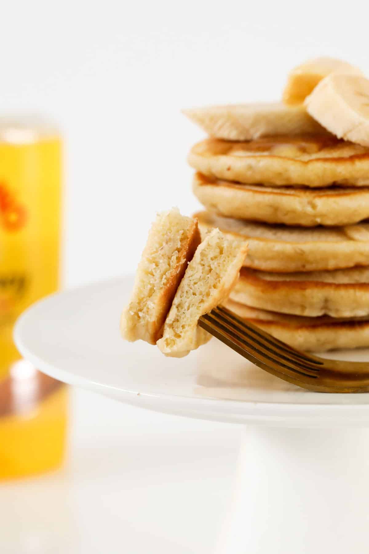Pieces of fluffy banana pikelets on a fork.