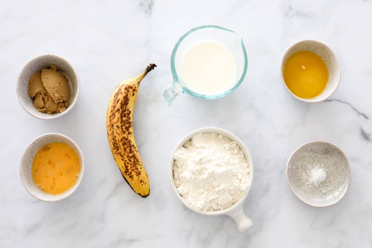The ingredients for banana pikelets on a marble bench.