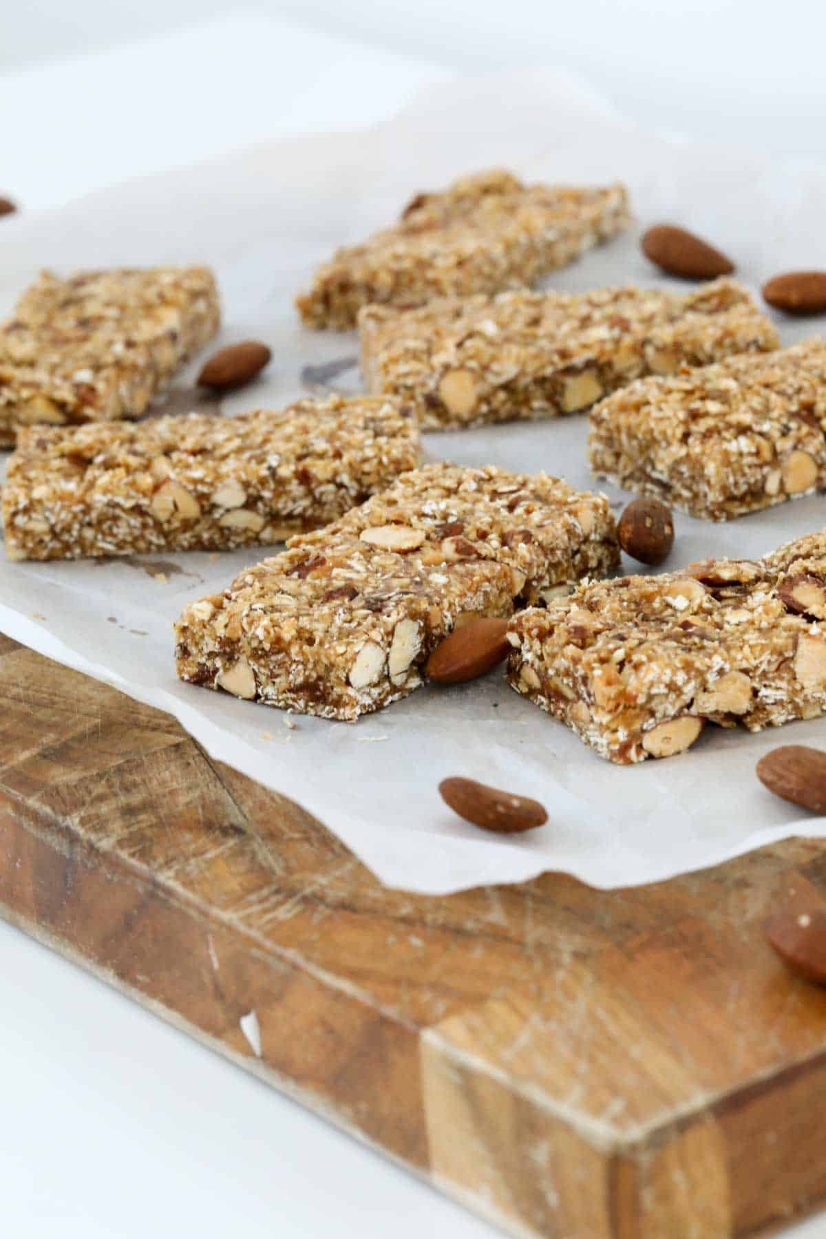 Peanut butter and almond bars cut into pieces on a chopping board.