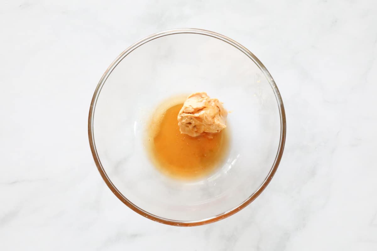 Peanut butter and honey in a glass bowl.