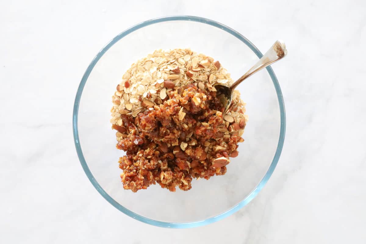 Almonds, chopped dates and oats in a mixing bowl