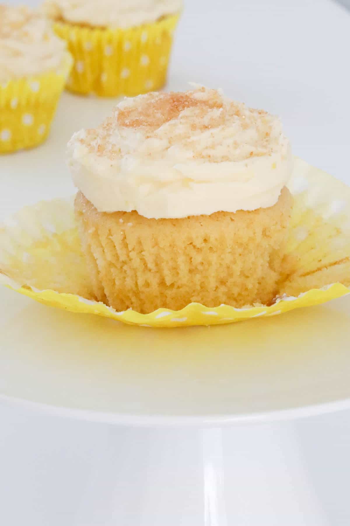 A lemon cupcake topped with creamy frosting and edible glitter.