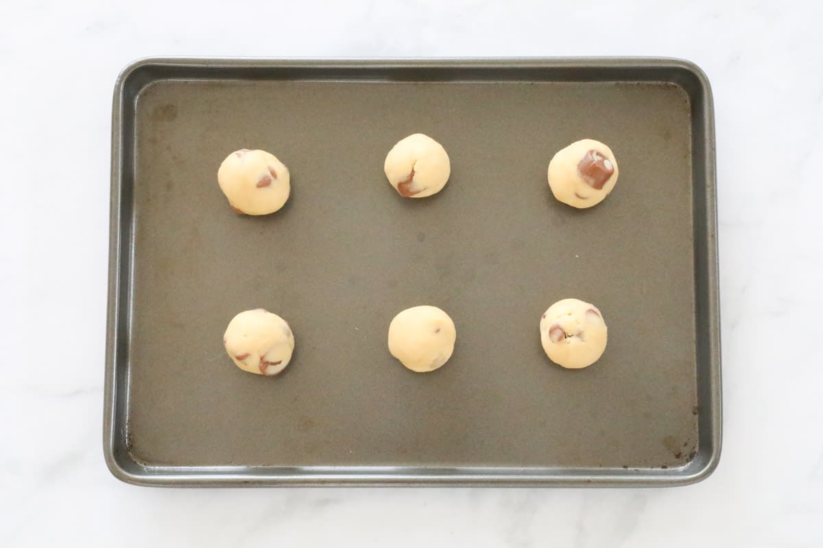Cookie dough balls on a baking tray.