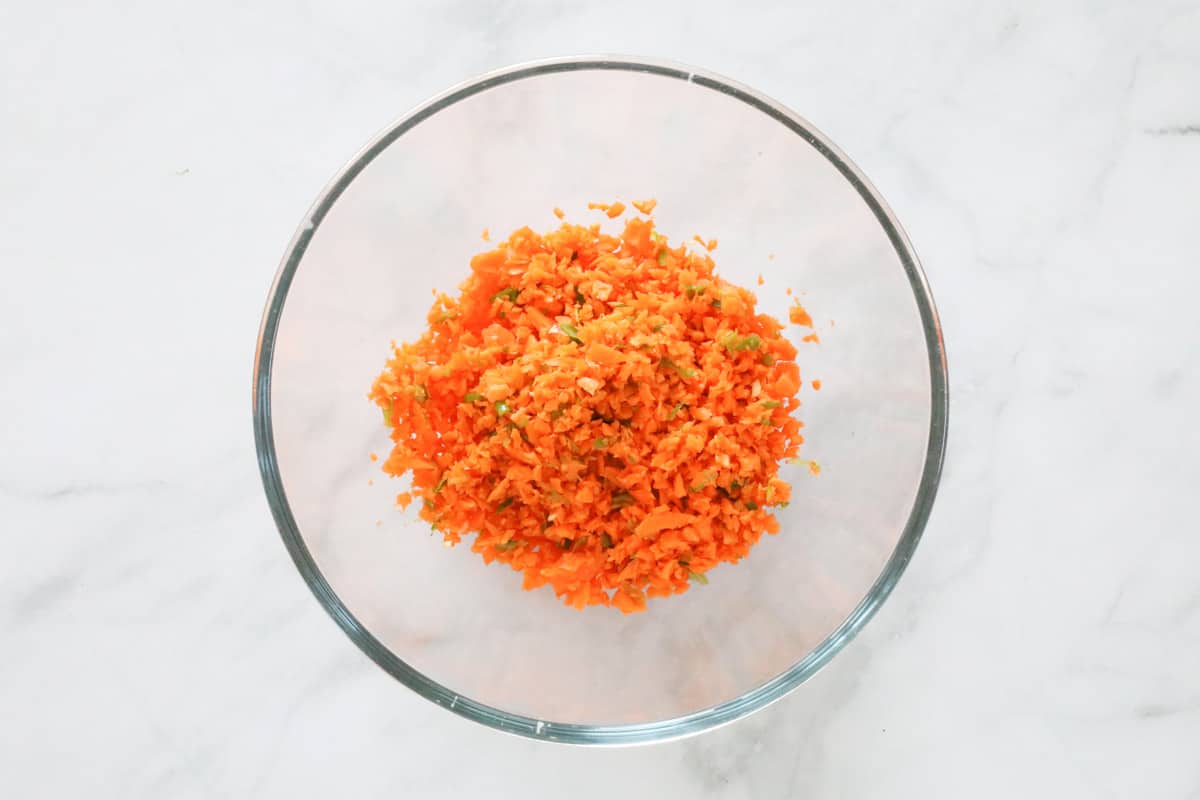 Finely chopped carrot and spring onions in a bowl.