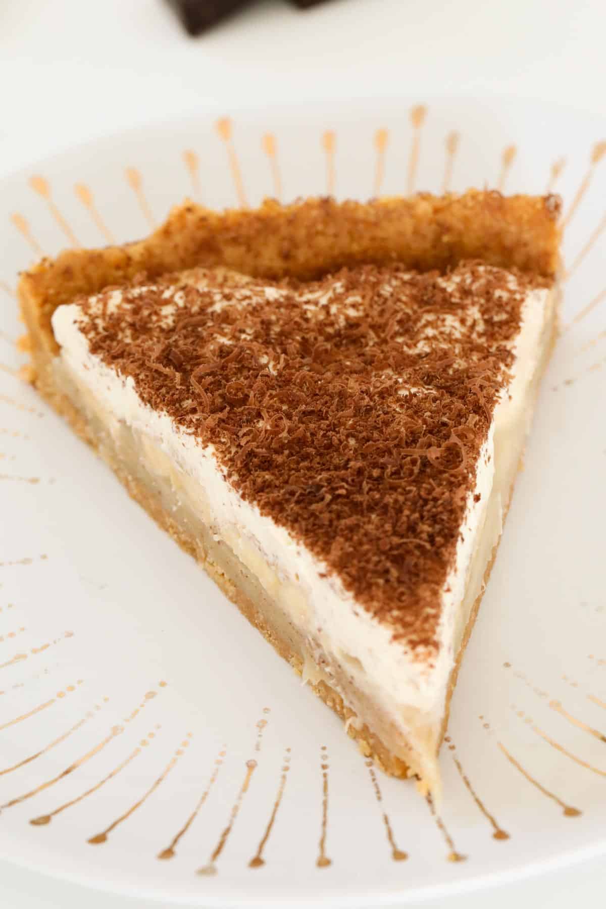 A serve of caramel pie sprinkled with grated chocolate on a white plate.
